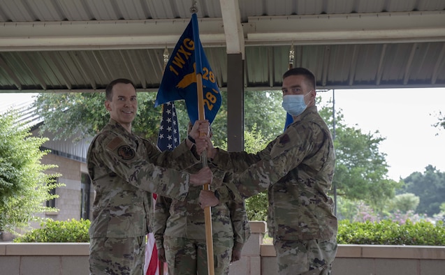(L to R) Col. Bradley Stebbins presents the 28th Operational Weather Squadron's guidon to Lt. Col. Daniel Muggelberg during an assumption of command ceremony on June 2, 2021, at Shaw Air Force Base, South Carolina.