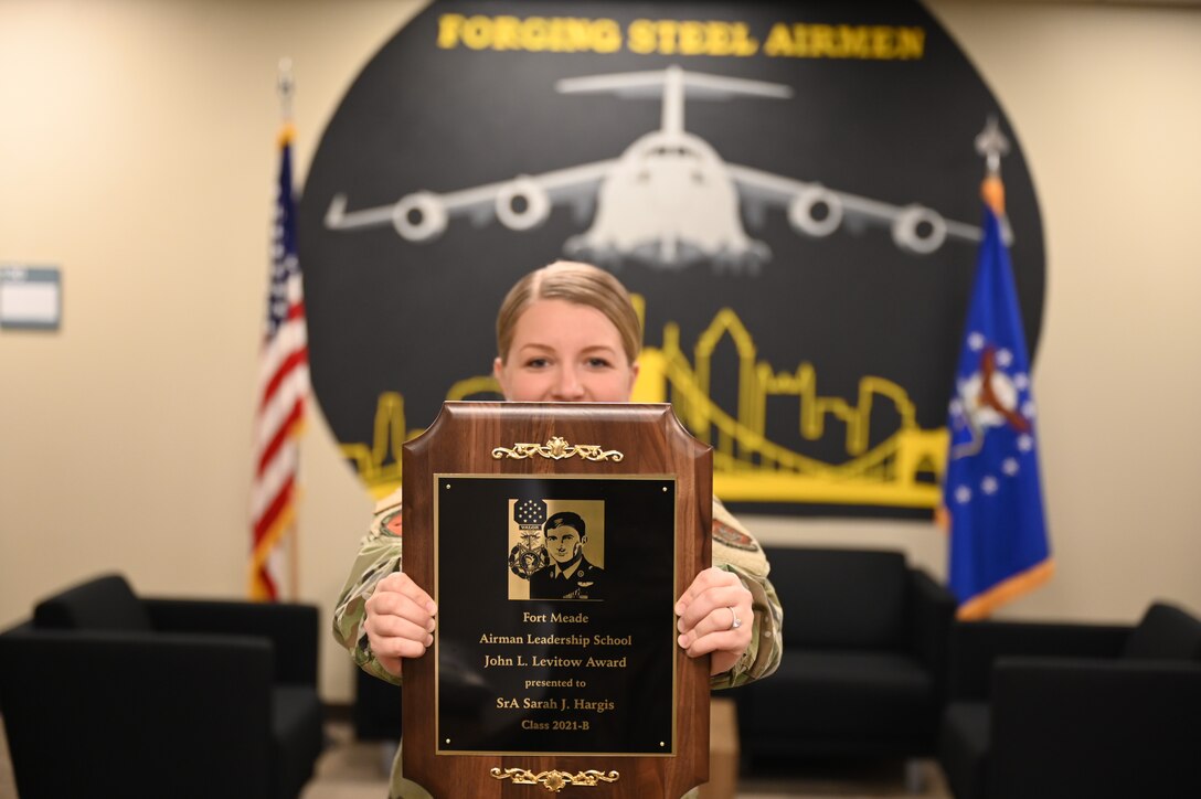 Senior Airman Sarah Hargis, 911th Logistics Readiness Squadron commander’s support staff, holds up the John L. Levitow Award at the Pittsburgh International Airport Air Reserve Station, Pennsylvania, April 11, 2021.