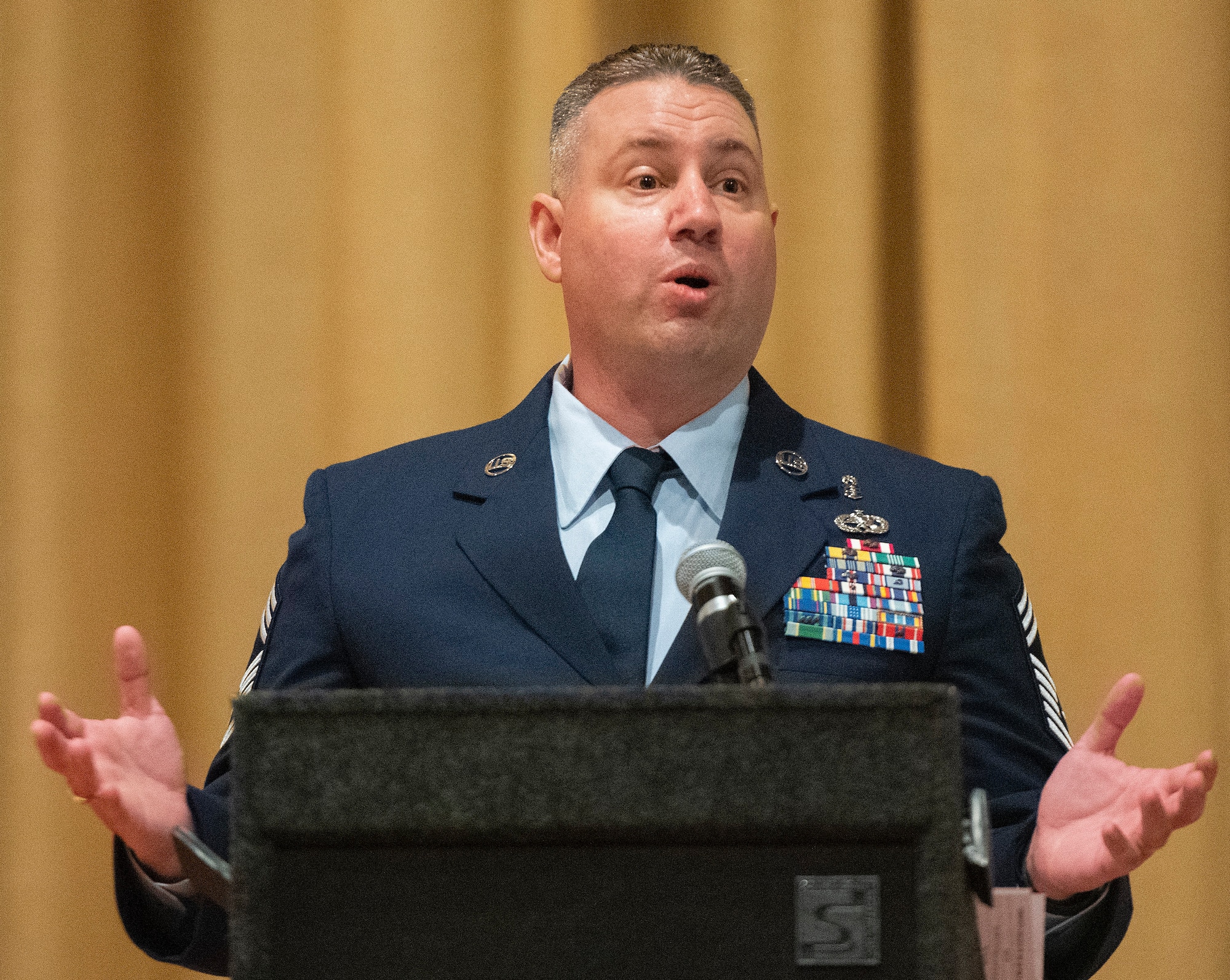Chief Master Sgt. Erik Robbins, U.S. Air Force School of Aerospace Medicine’s Occupational and Environmental Health Division superintendent, delivers the commencement address during the Community College of the Air Force spring graduation ceremony May 26, 2021, in the theater at Wright-Patterson Air Force Base, Ohio. Robbins urged the graduates to continue investing in their education. (U.S. Air Force photo by R.J. Oriez)