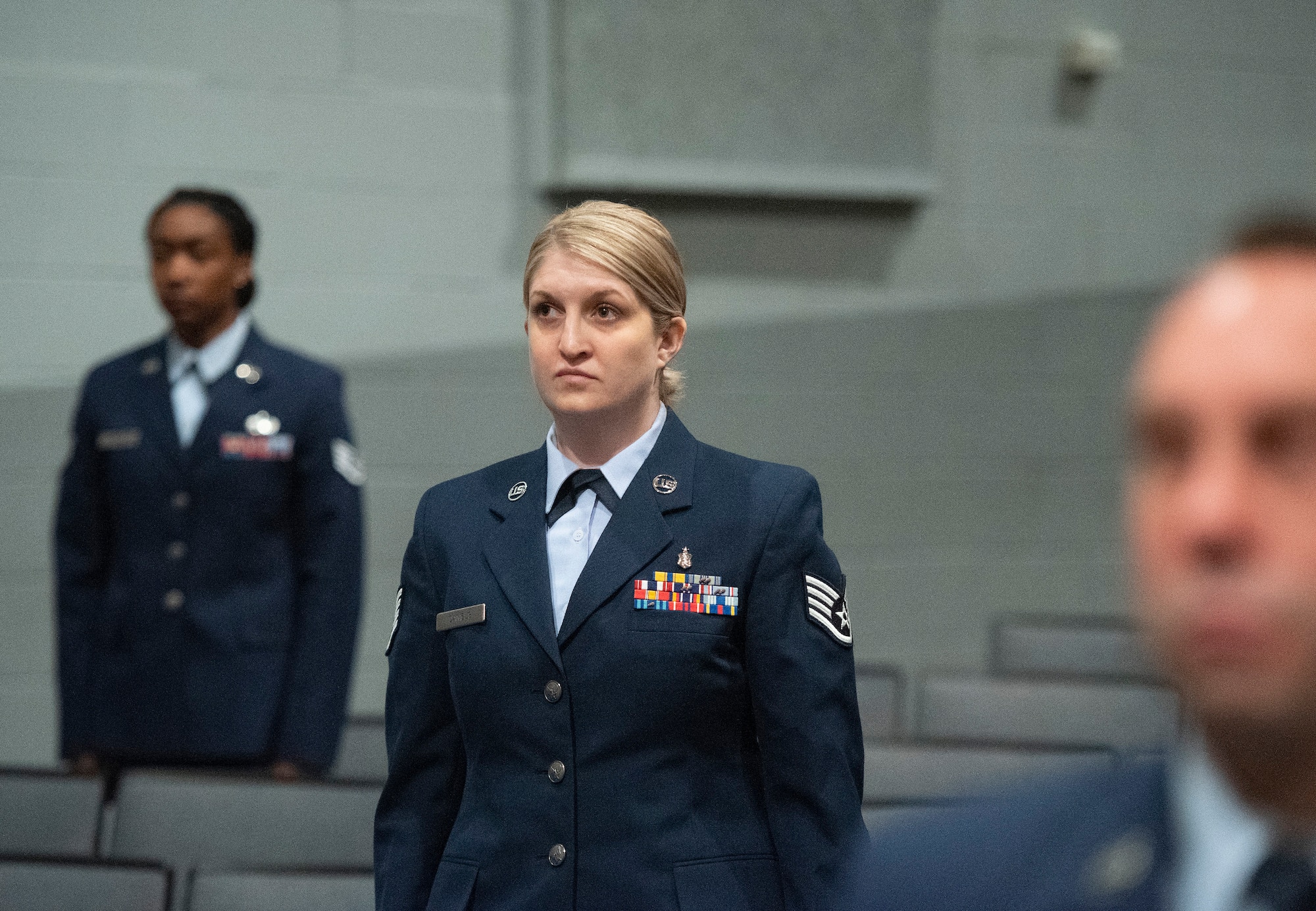 Staff Sgt. Victoria Daniels, U.S. Air Force School of Aerospace Medicine, stands with classmates as their degrees are conferred during the Community College of the Air Force spring graduation ceremony May 26, 2021, in the theater at Wright-Patterson Air Force Base, Ohio. Daniels earned an associate’s degree in instruction of technology and military science. (U.S. Air Force photo by R.J. Oriez)