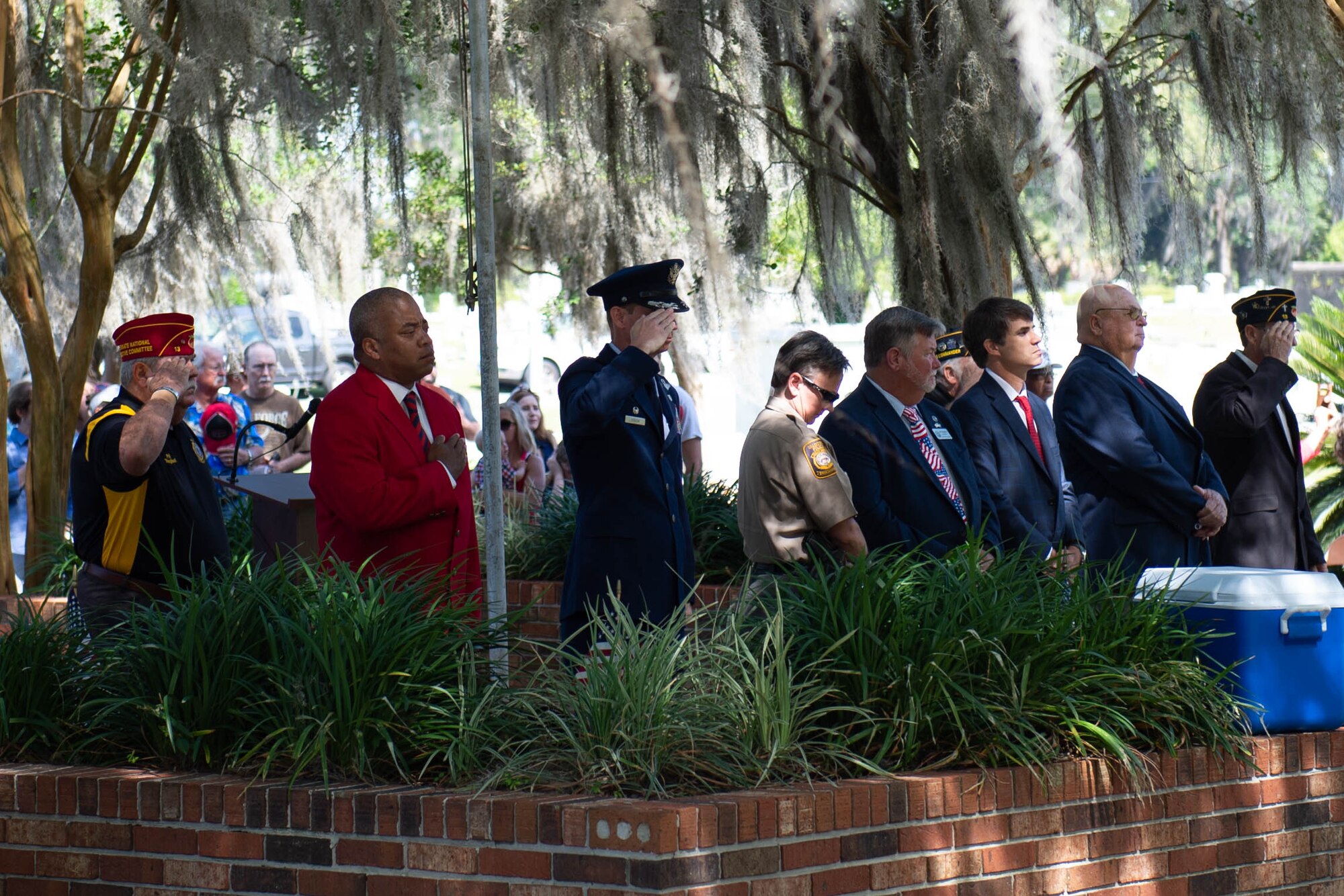A photo of attendees paying respects during taps.
