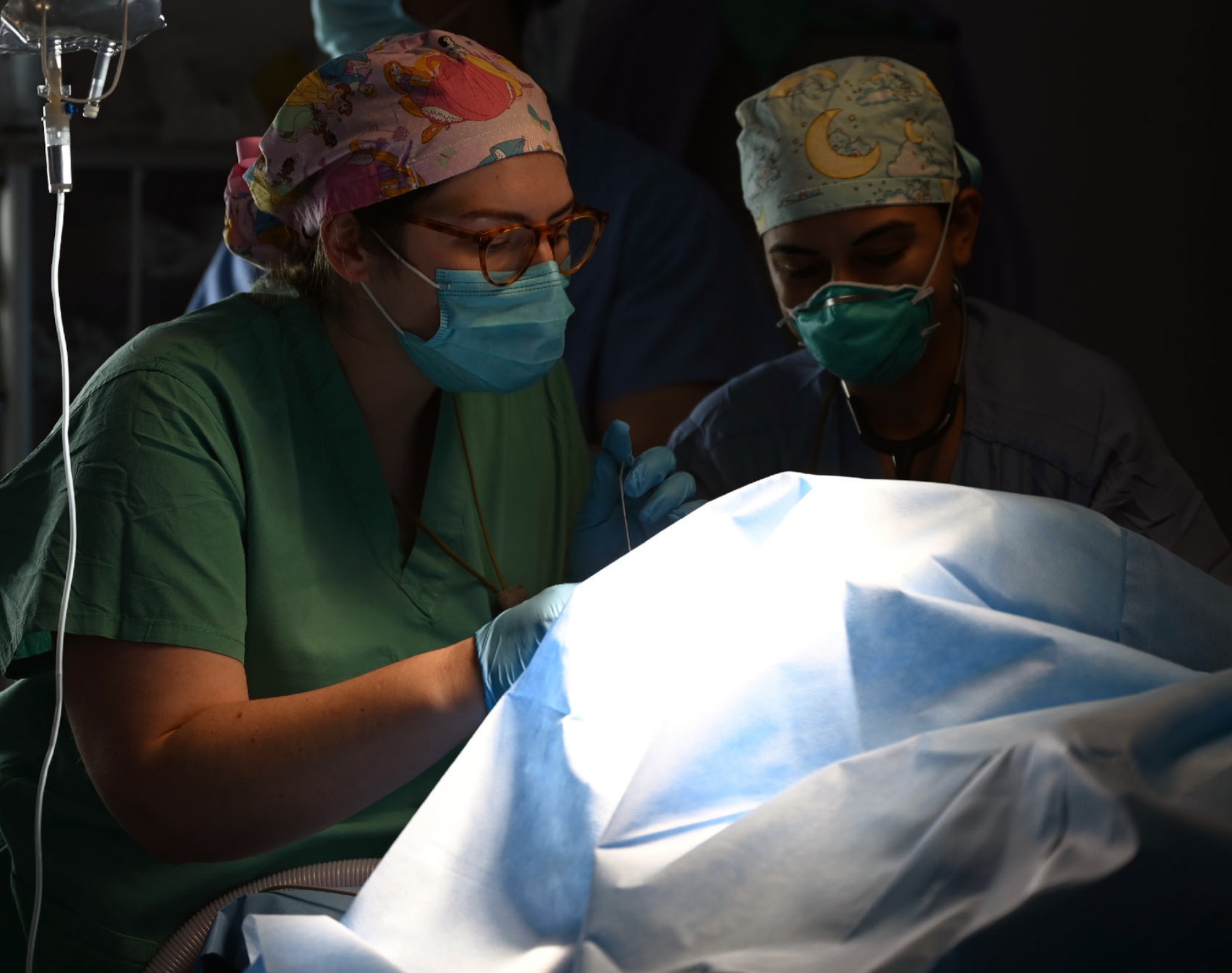 Air Force Capts. Courtney Hood and Kimpreet Kaur, anesthesia residents with the 59th Medical Wing, Joint Base San Antonio-Lackland, evaluate a patient at Hospital del Sur in Choluteca