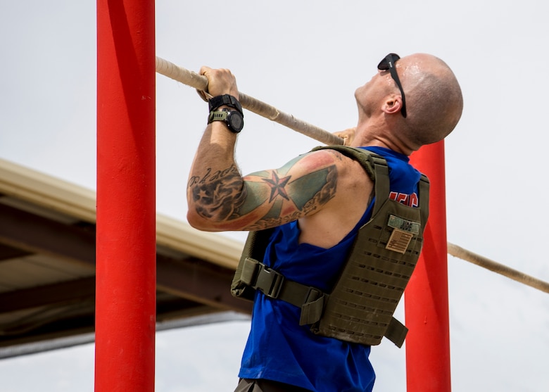 U.S. Marine Corps Gunnery Sgt. Eric Jude, the IMA maintenance chief with  Headquarters & Headquarters Squadron (H&HS), Marine Corps Air Station (MCAS) Yuma, performs pullups as a part of a squadron MURPH challenge on MCAS Yuma, Ariz., May 26, 2021. The MURPH is a workout challenge consisting of a 1 mile run, 100 pullups, 200 pushups, 300 squats, followed by another 1 mile run. The workout was a favorite of Lt. Michael P. Murphy, a Navy Seal who lost his life in Afghanistan. (U.S. Marine Corps Photo by Cpl. Joseph Exner)
