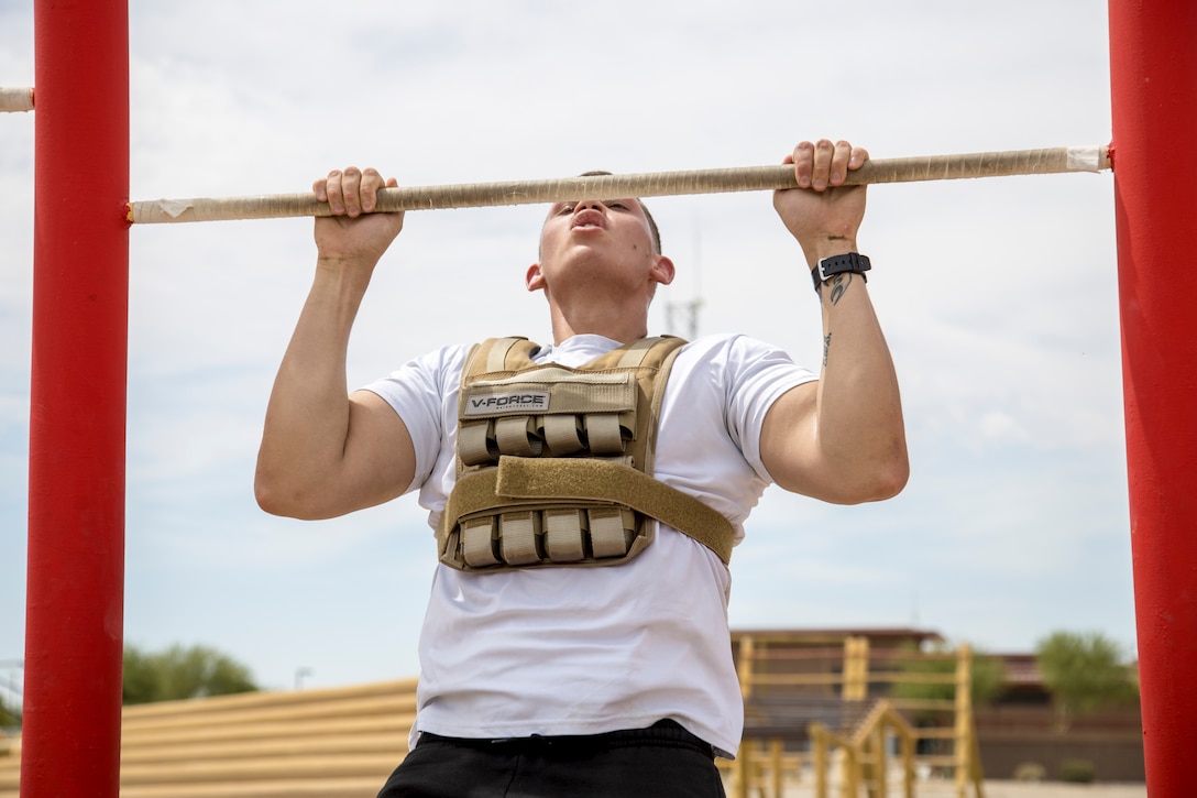 U.S. Marine Corps Cpl. Ronnie McPherson, a METOC analyst forecaster with Marine Air Control Squadron 1, Marine Corps Air Station (MCAS) Yuma, performs pullups as a part of a squadron MURPH challenge on MCAS Yuma, Ariz., May 26, 2021. The MURPH is a workout challenge consisting of a 1 mile run, 100 pullups, 200 pushups, 300 squats, followed by another 1 mile run. The workout was a favorite of Lt. Michael P. Murphy, a Navy Seal who lost his life in Afghanistan. (U.S. Marine Corps Photo by Cpl. Joseph Exner)