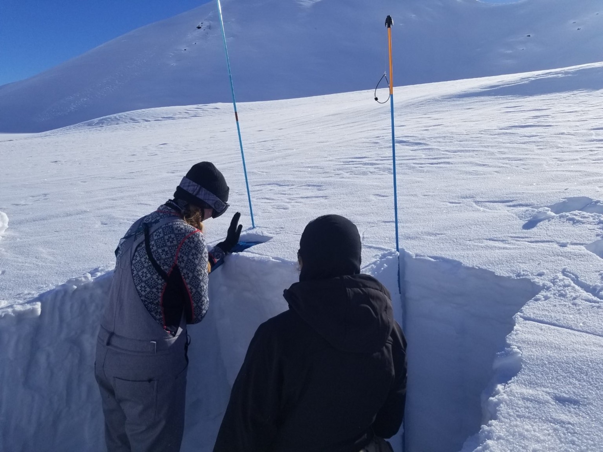 Capt. Lynsie Schwerer, Officer In Charge, Brigade Weather Operations, assigned to Detachment 3, 1st Combat Weather Squadron, Joint Base Elmendorf-Richardson, Alaska, performs a snow depth measurement during Arctic Survival Training. (Courtesy photo)