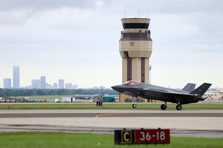 Airplane with air traffic control tower and downtown skyline in the background