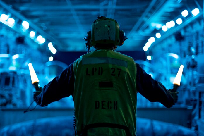 A U.S. Sailor assigned to amphibious transport dock USS Portland, signals Landing Craft, Air Cushion 72, with Assault Craft Unit 5, to depart the well deck for an amphibious raid exercise, May 17, 2021. Marines and Sailors of the 11th Marine Expeditionary Unit and the Essex Amphibious Ready Group are conducting integrated training off the coast of southern California.