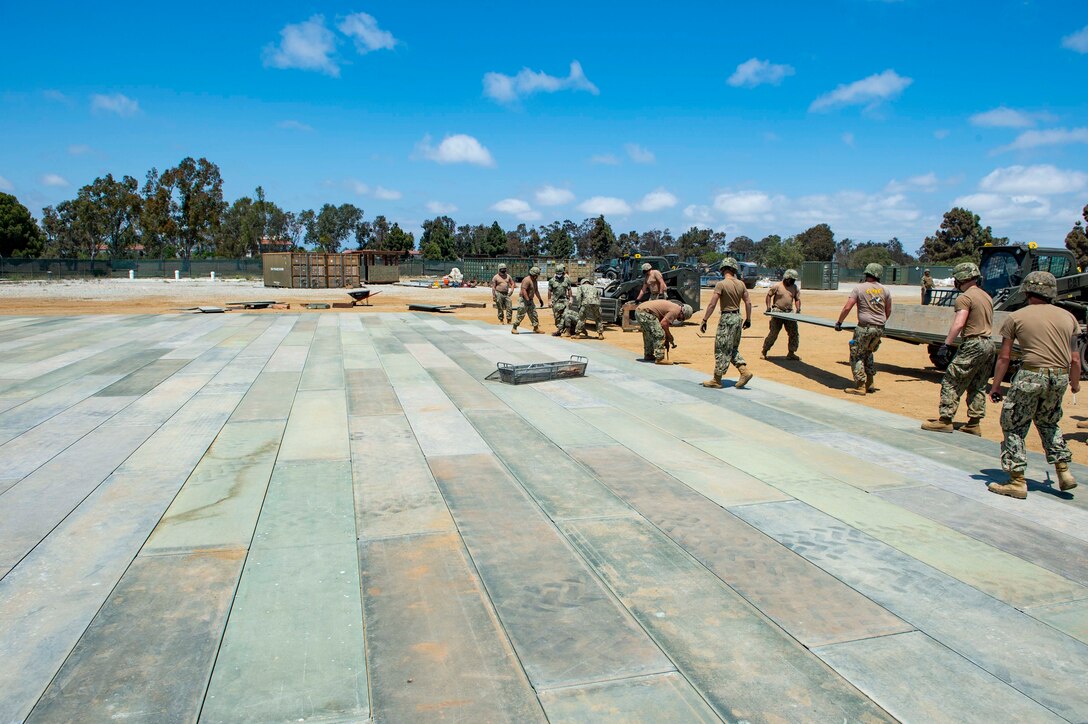 Seabees place AM-2 matting for a vertical take-off and landing site during an airfield damage repair assessment as part of Command Post Exercise 3 on board Naval Base Ventura County, Port Hueneme.