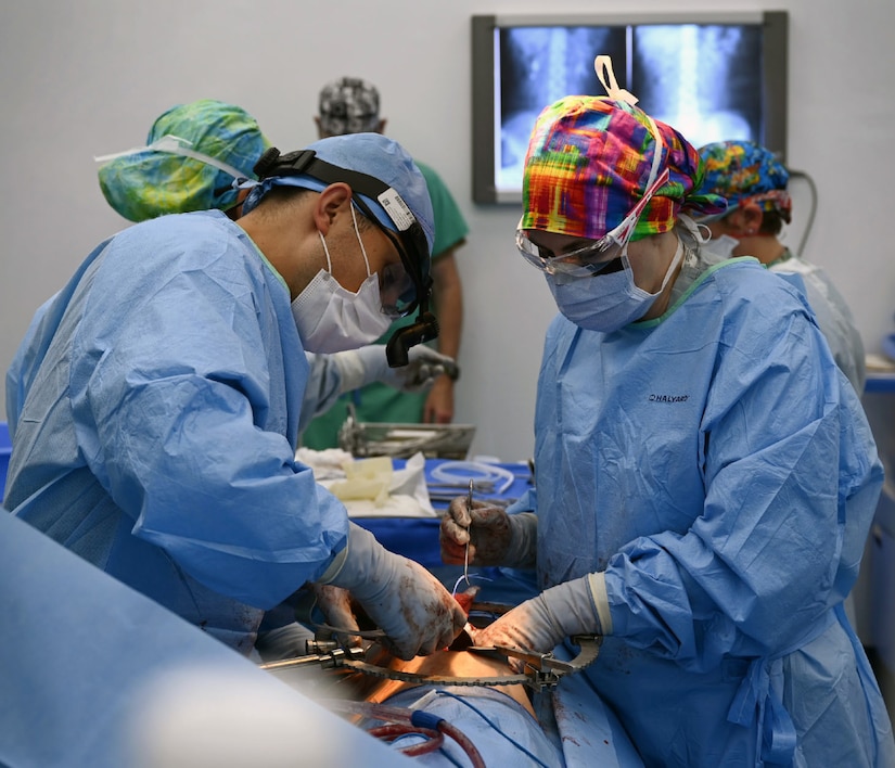 U.S. Army Lt. Col. Andrew Mendedorp (left), the chief of urology at Tripler Army Medical Center, Honolulu, Hawaii, and U.S. Air Force Lt. Col. Necia Pope (right), a urologist with the 59th Medical Wing, Joint Base San Antonio-Lackland, operate on a patient at Hospital del Sur in Choluteca,