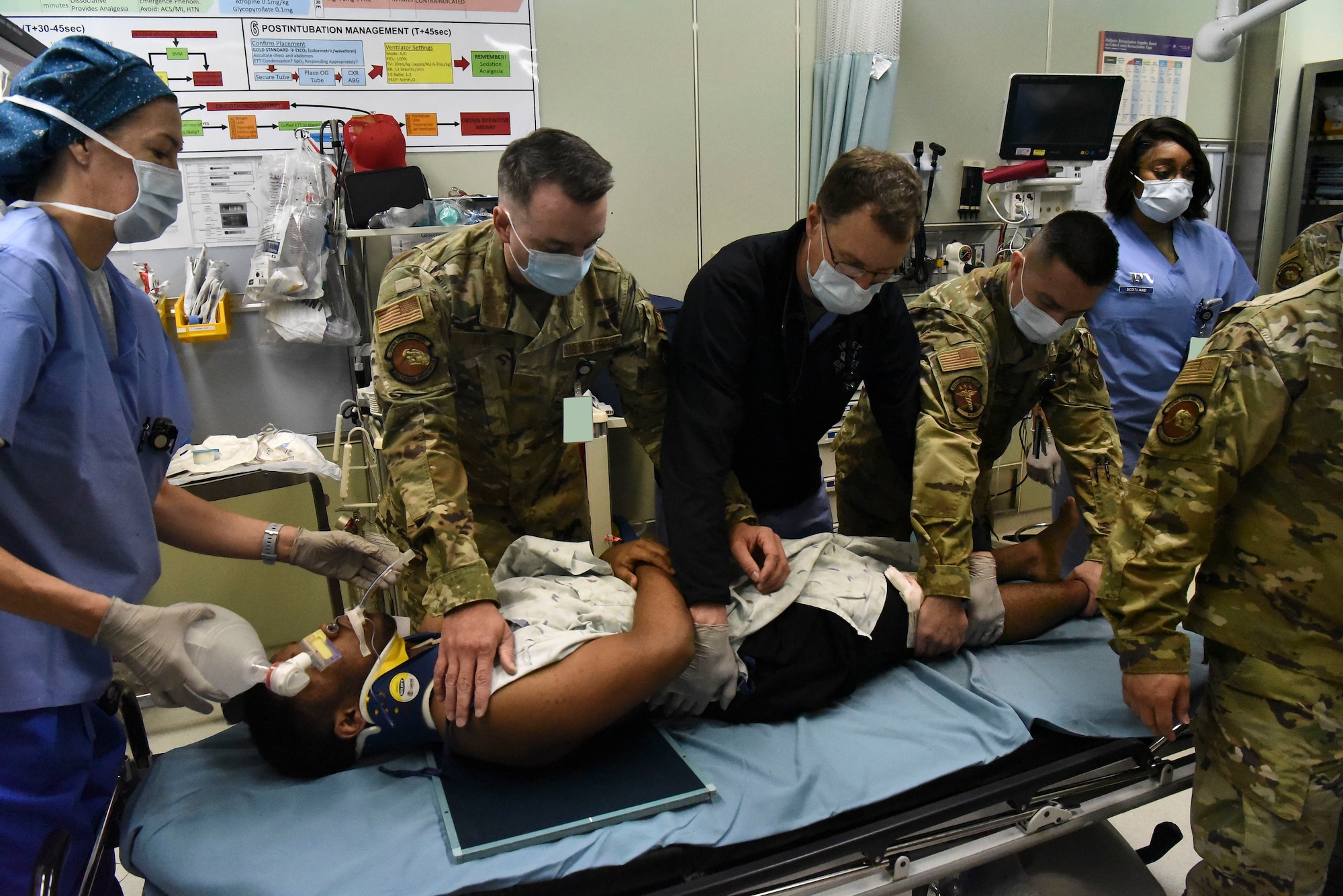 Medical care professionals turn a victim on his side to put X-ray panels under him.