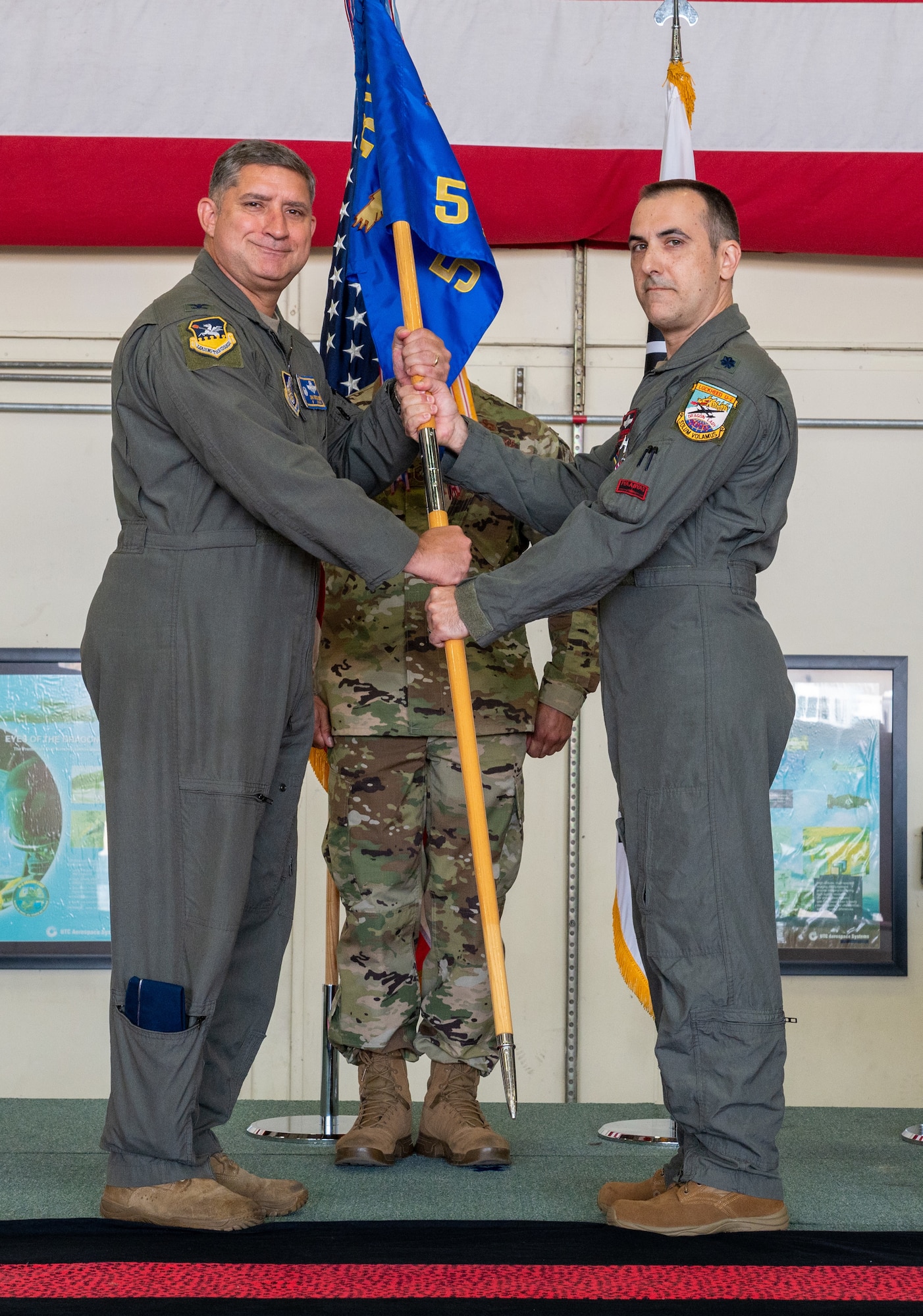 U.S. Air Force Col. John Gonzales, 51st Fighter Wing commander, left, receives the 5th Reconnaissance Squadron guidon from Lt. Col. Eugene Georgescu, 5th RS commander, during the 5th RS change of command at Osan Air Base, Republic of Korea, June 4, 2021. This transfer of command is physically represented by passing the guidon, the tangible symbol of the unit, from the out-going commander and incoming. (U.S. Air Force photo by Senior Airman Branden Rae)