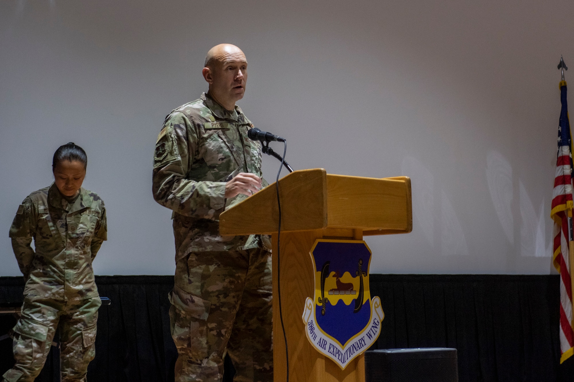 Man in uniform speaks on stage.