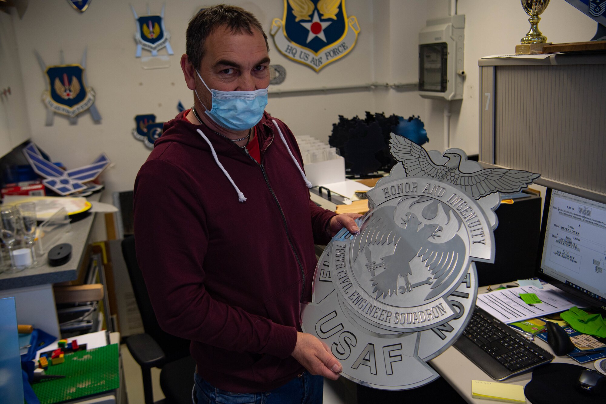 Michael Heinz holds a sign that he created at the paint and sign shop.