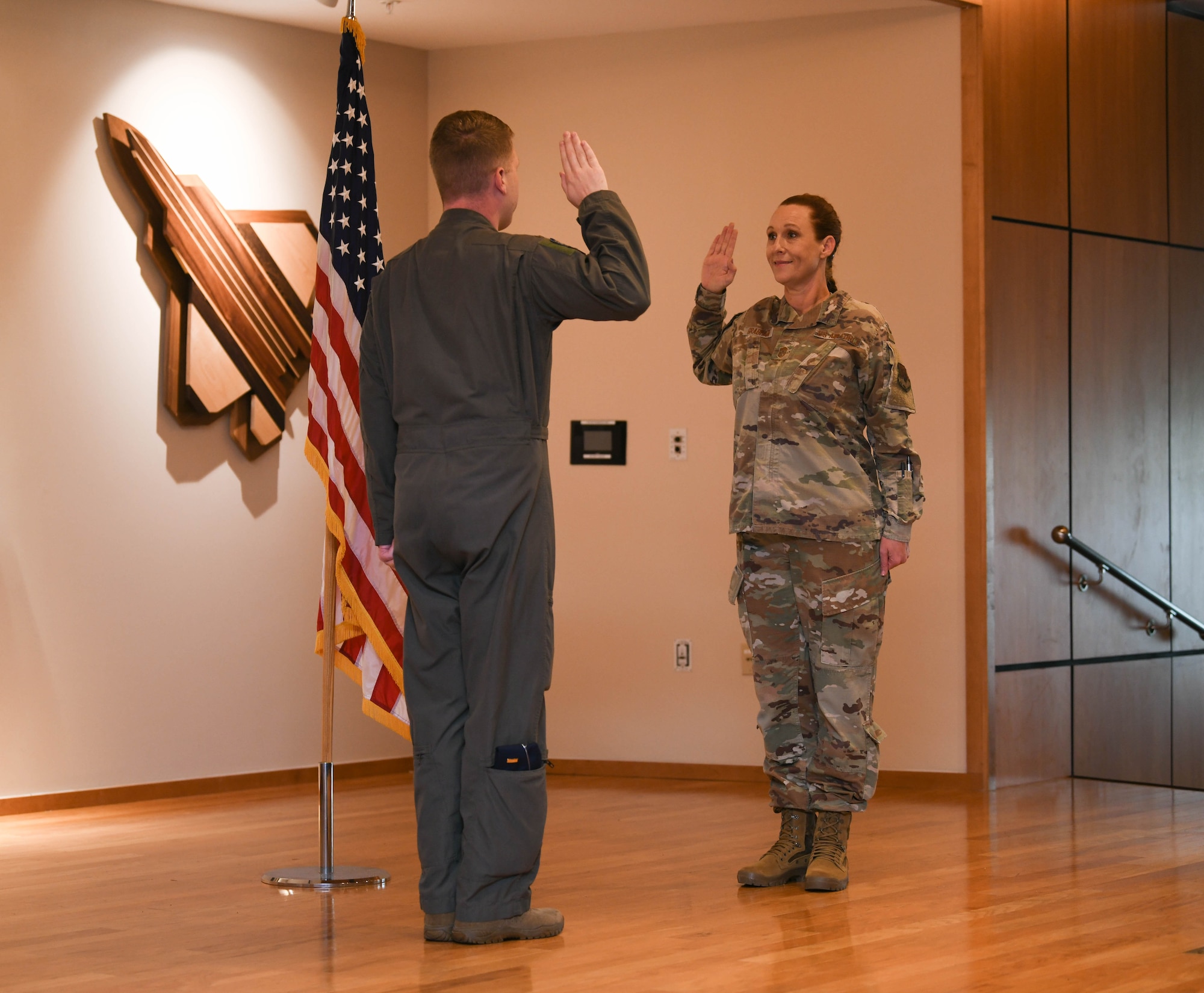 Grabham and Garcia hold their right hands up during the oath of enlistment