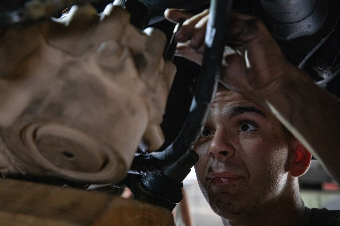 U.S. Marine Corps Lance Cpl. Garret Mathena, an automotive maintenance technician, works under a medium tactical vehicle replacement on Dobbins Air Force Base, Georgia, May 2, 2021. Marines with 2nd Transportation Battalion, Combat Logistics Regiment 2, 2nd Marine Logistics Group conducted a convoy across the United States starting in Camp Lejeune, North Carolina and arriving at Marine Corps Air Ground Combat Center Twentynine Palms, California, in on of the longest convoys in recent Marine Corps history. (U.S. Marine Corps photo by Lance Cpl. Scott Jenkins)