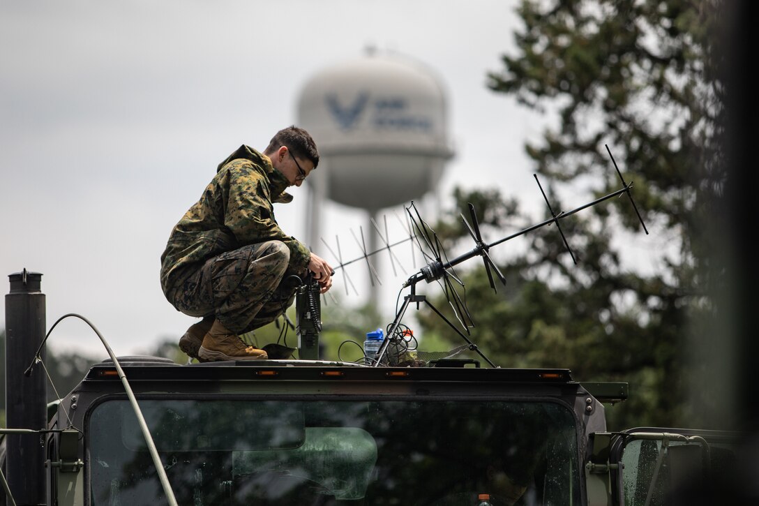 U.S. Marine Corps Cpl. Craig Wallace, a ground electronics transmissions system maintainer, sets up a radio on top of a logistics vehicle systems replacement on Columbus Air Force Base, Mississippi, May 4, 2021. Marines with 2nd Transportation Battalion, Combat Logistics Regiment 2, 2nd Marine Logistics Group conducted a convoy across the United States starting in Camp Lejeune, North Carolina and arriving at Marine Corps Air Ground Combat Center Twentynine Palms, California, in on of the longest convoys in recent Marine Corps history. (U.S. Marine Corps photo by Lance Cpl. Scott Jenkins)