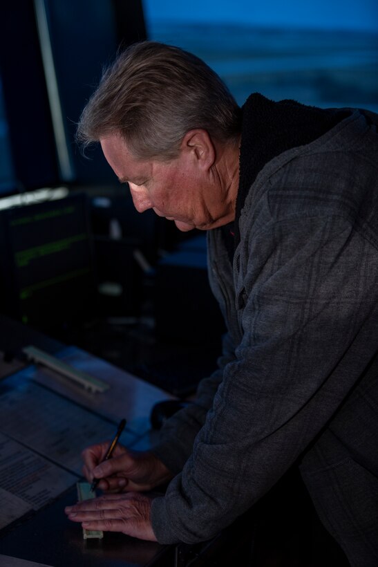 Edward Terhune, 45th Logistics Readiness Squadron air traffic controller, writes down information inside the tower at Patrick Space Force Base, Fla., May 26, 2021. Terhune has been an ATC for 40 years and was working in the tower when a TBM Avenger crashed in the ocean during the Cocoa Beach Air Show April 17. (U.S. Space Force photo by Tech. Sgt. James Hodgman)