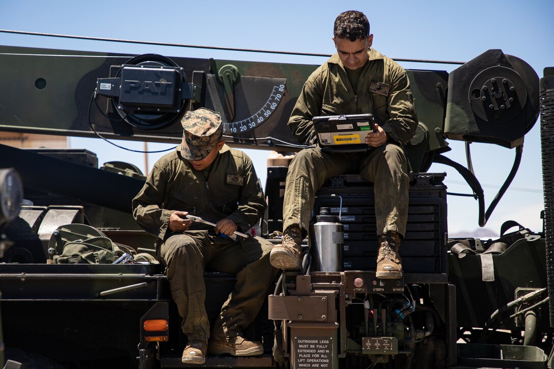 U.S. Marine Corps Lance Cpl. Garret Mathena, right, and Pfc. Hector LuceroLopez, both automotive maintenance technicians, look at mechanical instructions on Fort Huachuca, Arizona, May 20, 2021. Marines with 2nd Transportation Battalion, Combat Logistics Regiment 2, 2nd Marine Logistics Group conducted a convoy across the United States starting in Camp Lejeune, North Carolina, in one of the longest convoys in recent Marine Corps history. Marines on the convoy experimented with long-range communications, as far away as Marine Corps Air Ground Combat Center Twentynine Palms, California, the half-way point on the route. (U.S. Marine Corps photo by Lance Cpl. Scott Jenkins)