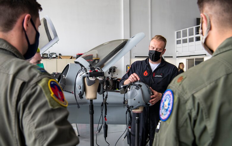 Glenn Snyder, Red 6 hardware developer, center, describes the hardware used for their augmented reality headsets in Santa Monica, Calif., April 13, 2021.