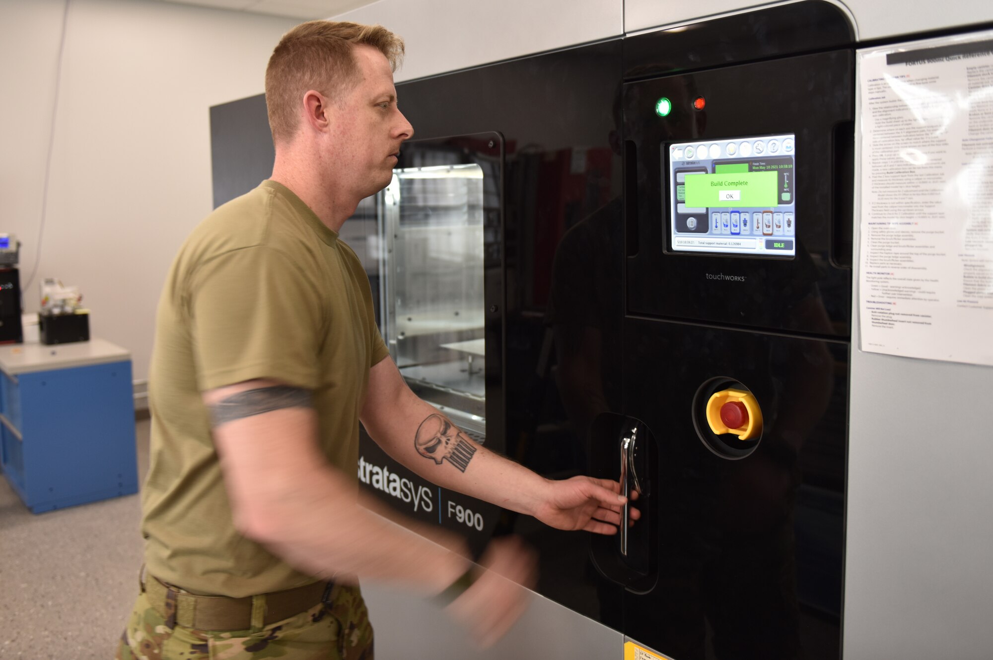 Master Sgt. Michael Howard, 911th Maintenance Squadron aircraft metals technician, reaches for the door of the fabrication flight's first 3D printer to remove a prototype aircraft part at the Pittsburgh International Airport Air Reserve Station, May 10, 2021.