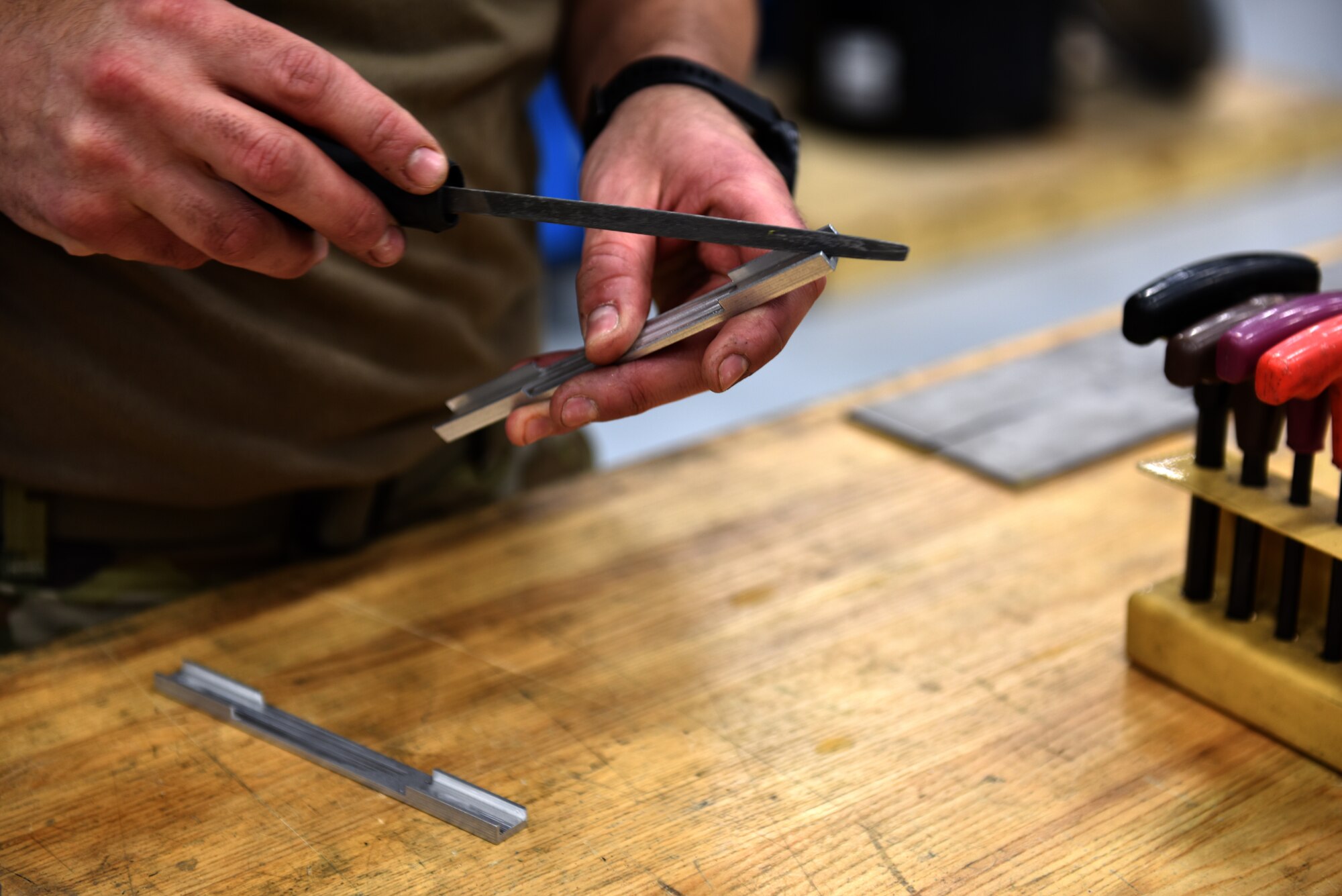 Staff Sgt. Ryan Burick, 911th Maintenance Squadron aircraft metals technician, uses a hand file to deburr the sharp edge of a C-17 Globemaster III component after removing the part from a CNC machine at the Pittsburgh International Airport Air Reserve Station May 10, 2021.