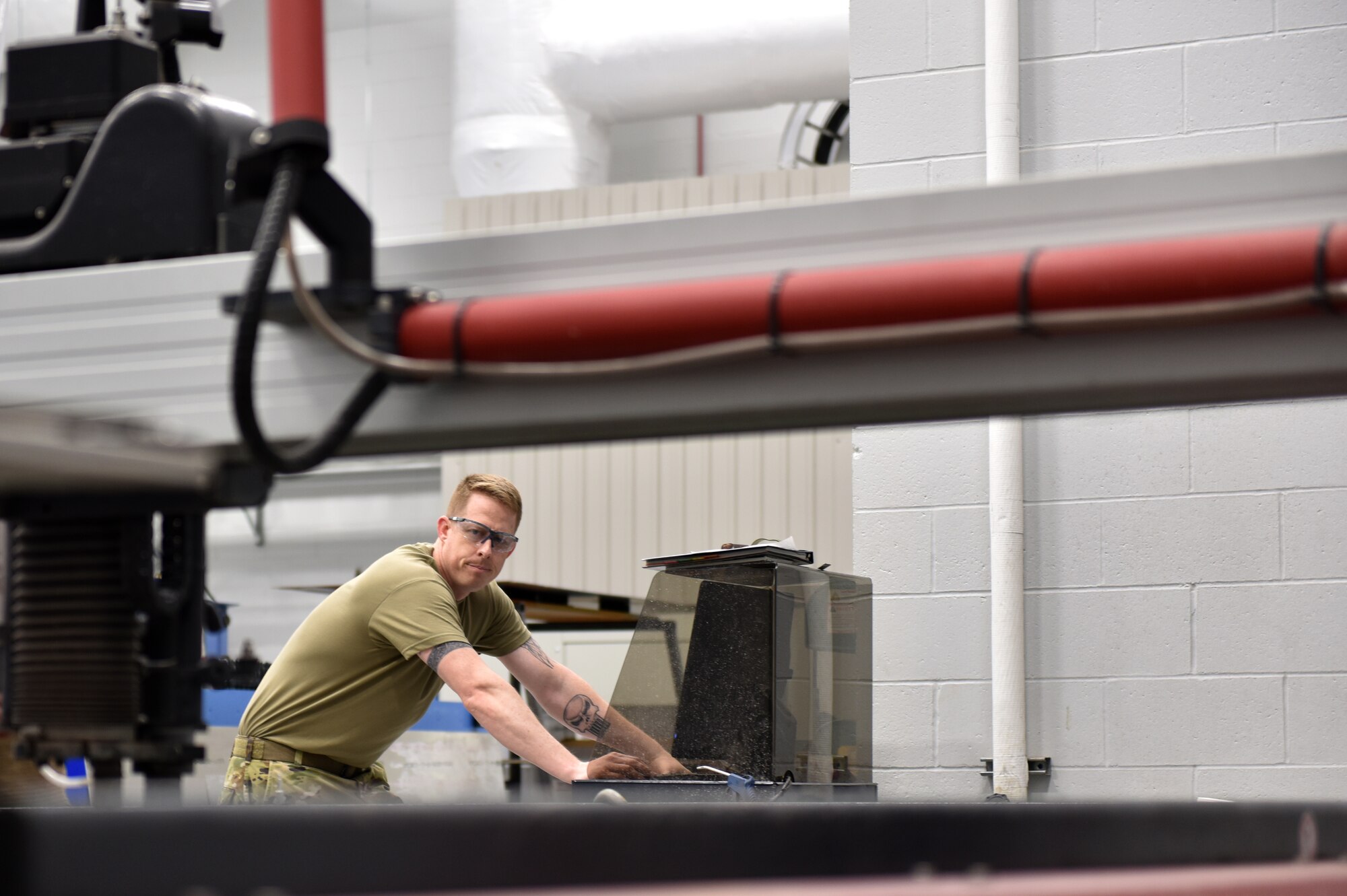 Master Sgt. Michael Howard, aircraft metals technician of the 911th Maintenance Squadron fabrication flight, monitors the automated water jet cutting machine during the initial cutting process of an aircraft part at the Pittsburgh International Airport Air Reserve Station, May 10, 2021.