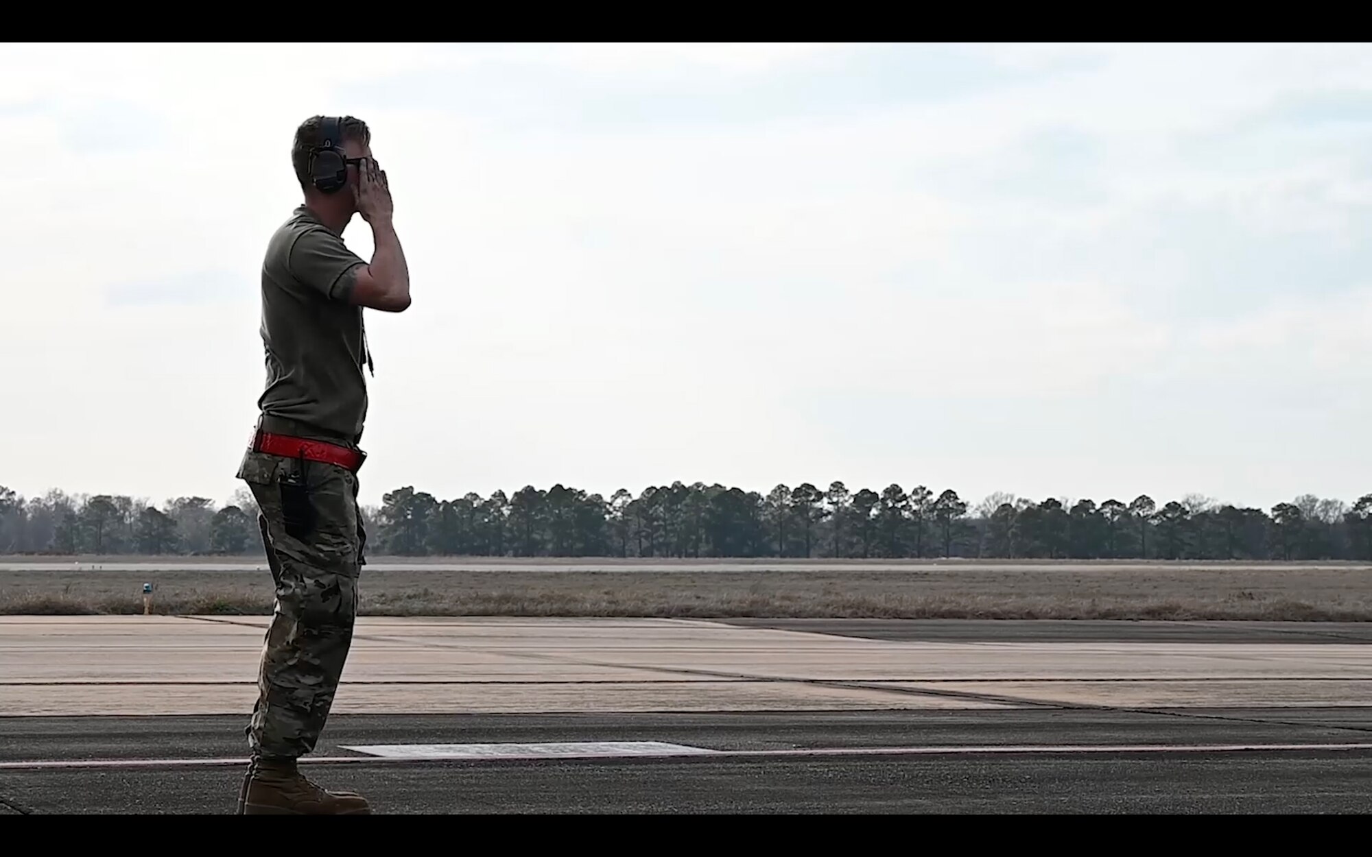 man salutes and aircraft before it departs