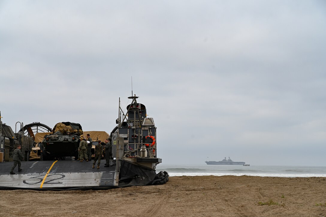 U.S. Marines and Sailors with the 15th Marine Expeditionary Unit offload from a landing craft, air cushion, assigned to Assault Craft Unit 5, Naval Beach Group 1, from the amphibious assault ship USS Makin Island (LHD 8) onto Red Beach at Marine Corps Base Camp Pendleton, California, May 19, 2021. The 15th MEU, embarked aboard Makin Island Amphibious Ready Group, returned from a seven-month deployment to the U.S. 3rd, 5th, 6th, and 7th Fleet areas of operation, serving as a crisis-response force for combatant commanders in the Africa, Central and Indo-Pacific commands. (U.S. Marine Corps photo by Cpl. Britany Rowlett)