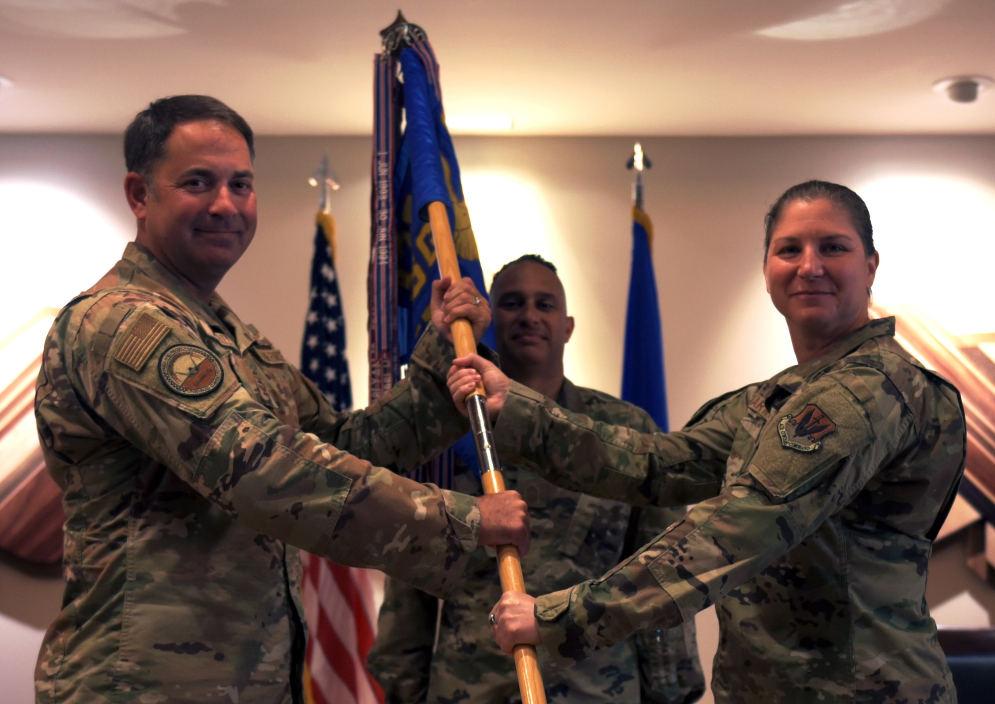 Two people hold a guidon