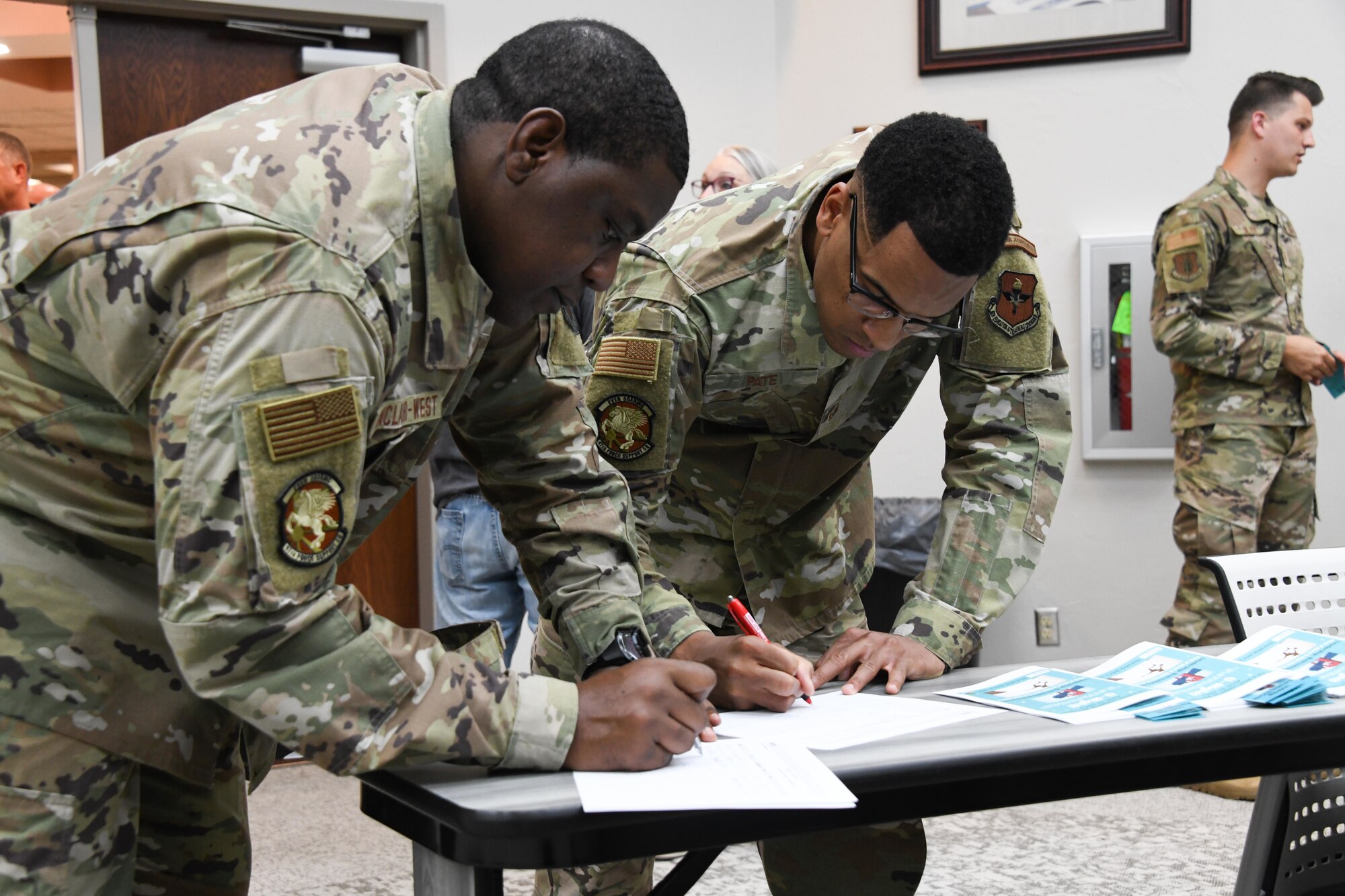 two people sign paper