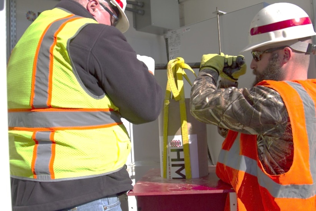 Technicians remove induction hot mix asphalt (iHMA) material containing steel particles from the induction unit capable of heating the asphalt to 300 degrees in under five minutes.