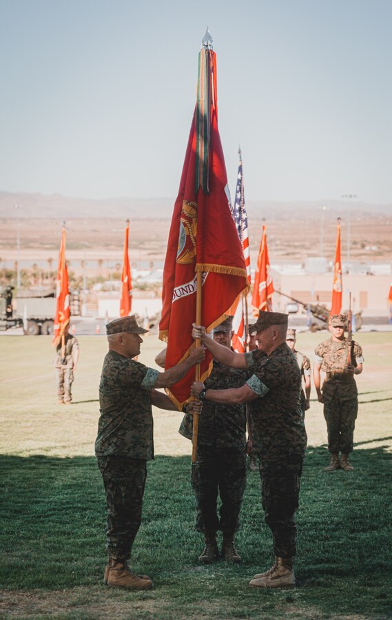 U.S. Marine Corps Maj. Gen. William M. Jurney (right), out-going commanding general, passes organizational colors to incoming commanding general Maj. Gen. Austin E. Renforth, during the Marine Air Ground Task Force Training Command, Marine Corps Air Ground Combat Center change of command ceremony on June 4, 2021. (U.S. Marine Corps photo by Lance Cpl. Colton Brownlee)