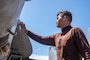 Aviation Structural Mechanic 3rd Class Lawrence Belancik, from Dededo, Guam, washes an F/A-18E Super Hornet on the flight deck of USS Ronald Reagan (CVN 76)