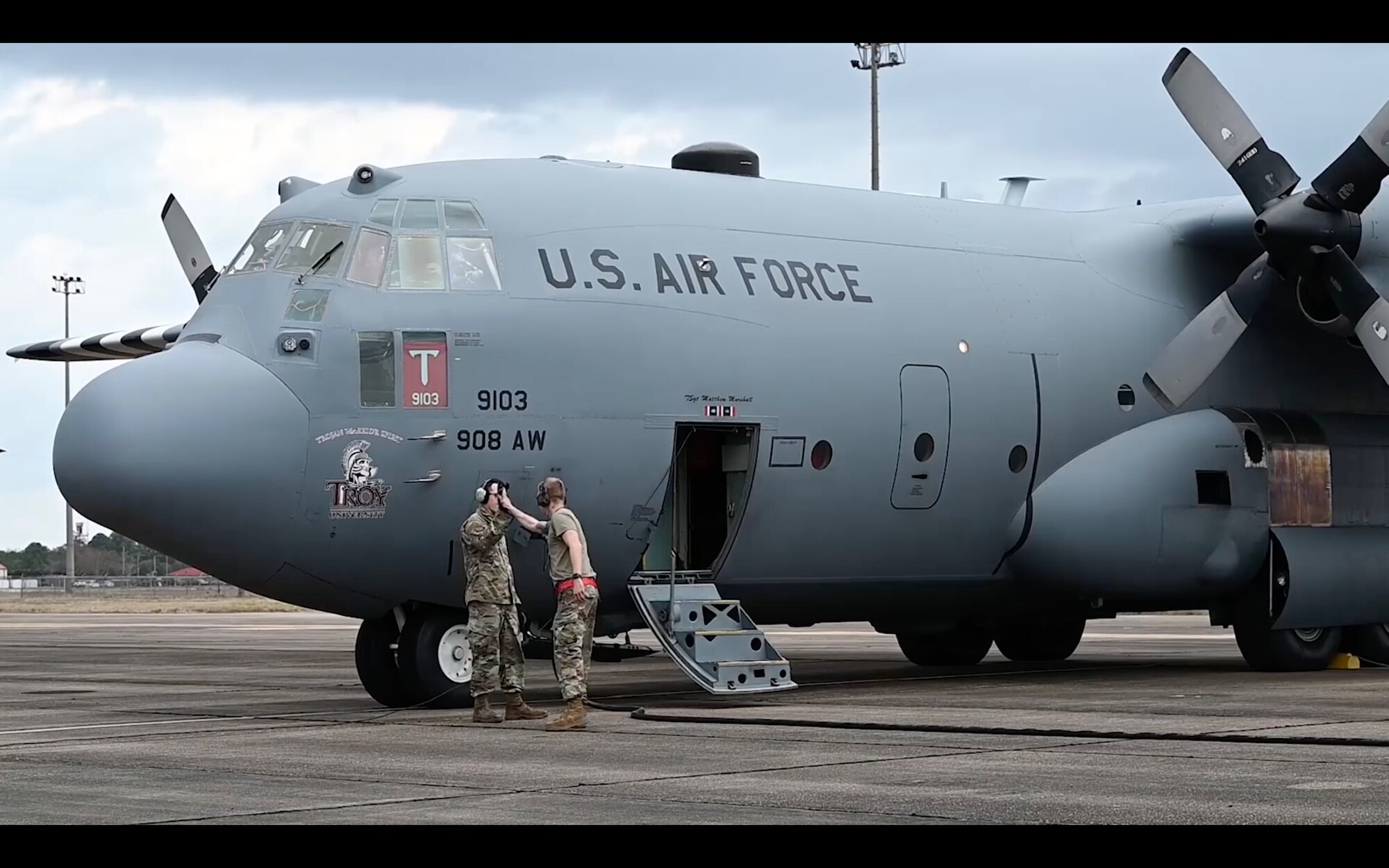two airmen share a high five next to an aircraft