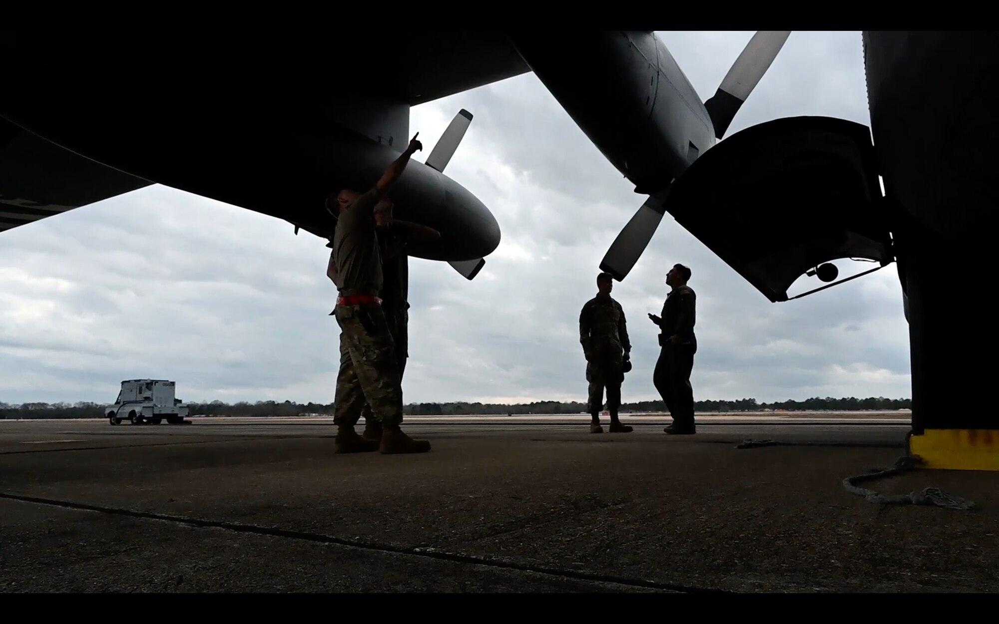 4 people standing under an aircraft