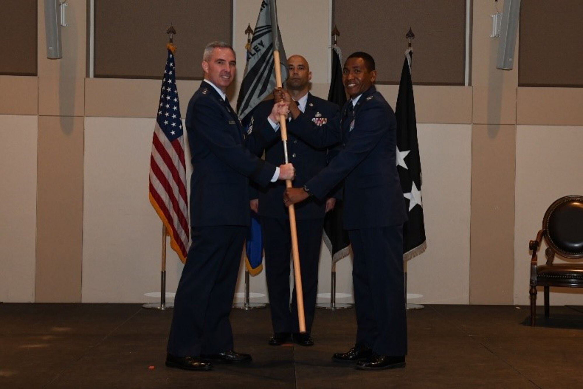Col. Marcus Jackson, right, incoming Buckley Garrison commander, receives the guidon from Lt. Gen. Stephen Whiting, left, Space Operations Command commander, during the Buckley Garrison Assumption of Command Ceremony at Buckley Space Force Base, Colo., June 4, 2021. The passing of the guidon is a symbolic tradition accomplished in front of the unit so all can witness the new commander assuming the position. (U.S. Space Force photo by Senior Airman Danielle McBride)