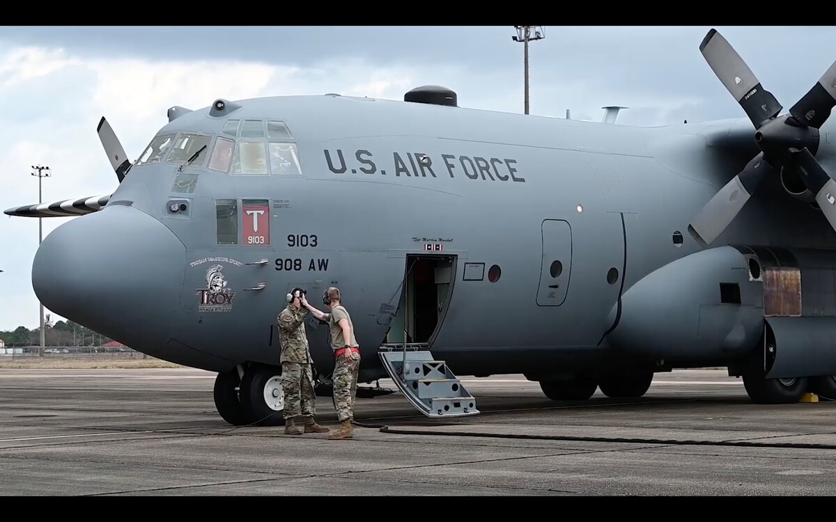 two airmen share a high five next to an aircraft