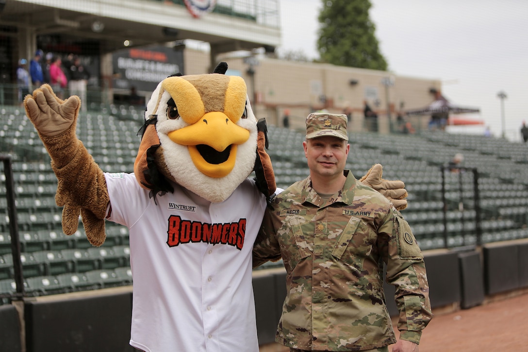 Maj. Scott Hager, Headquarters and Headquarters Company commander for the 85th U.S. Army Reserve Support Command, pauses for a photo with “Coop”, the Mascot for the Schaumburg Boomers baseball team, before the Boomers Memorial Day home game vs. the Gateway Grizzlies at Wintrust Field, May 31, 2021.