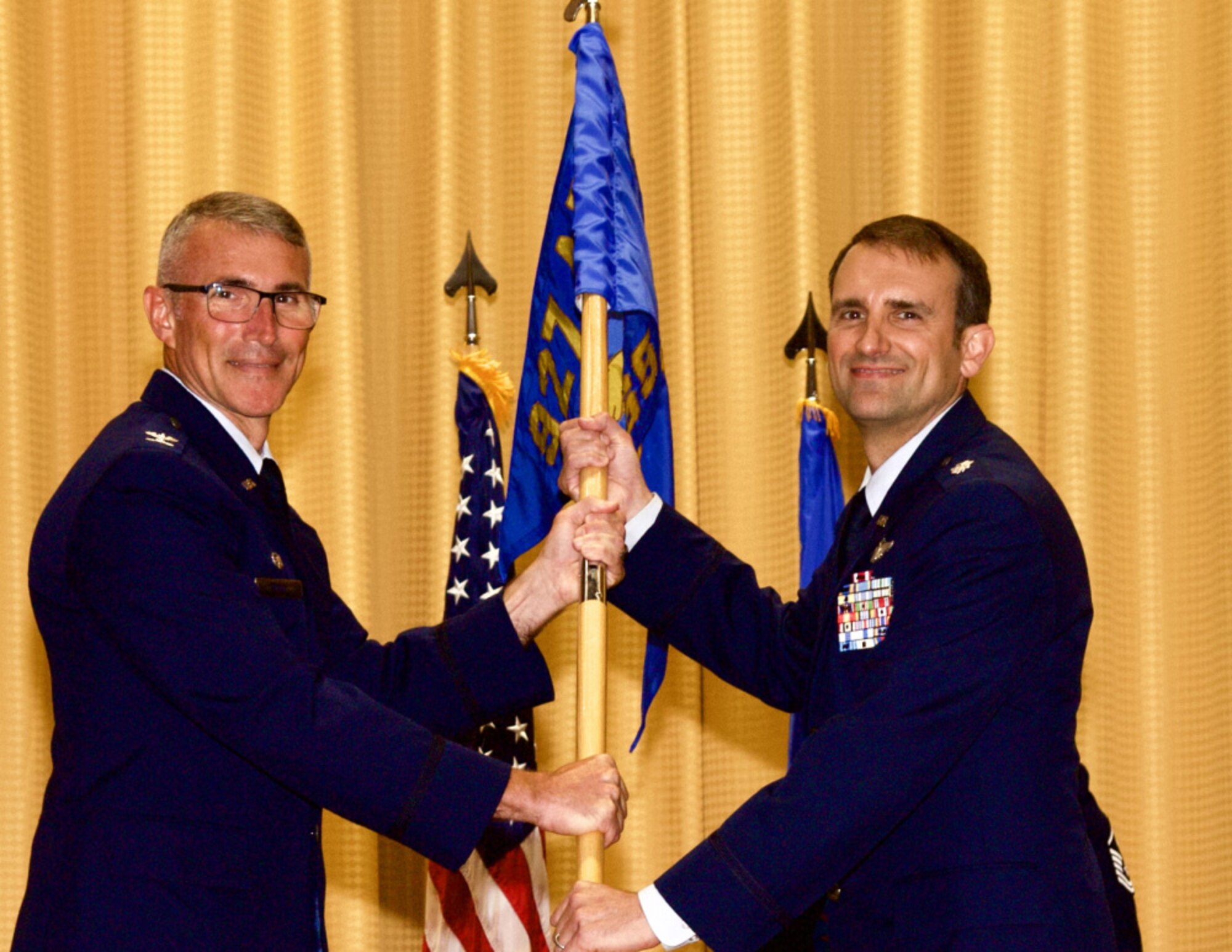 Col. James Mach, 927th Operations Group Commander passes the 927th Operations Support Squadron guidon to Lt. Col. Michael Albert during a change of command ceremony on MacDill Air Force Base, Florida, June 5, 2021. Albert assumed command of the 927th OSS from Lt. Col. Benjamin Ward. (U.S. Air Force photo by Staff Sgt. Tiffany Emery)