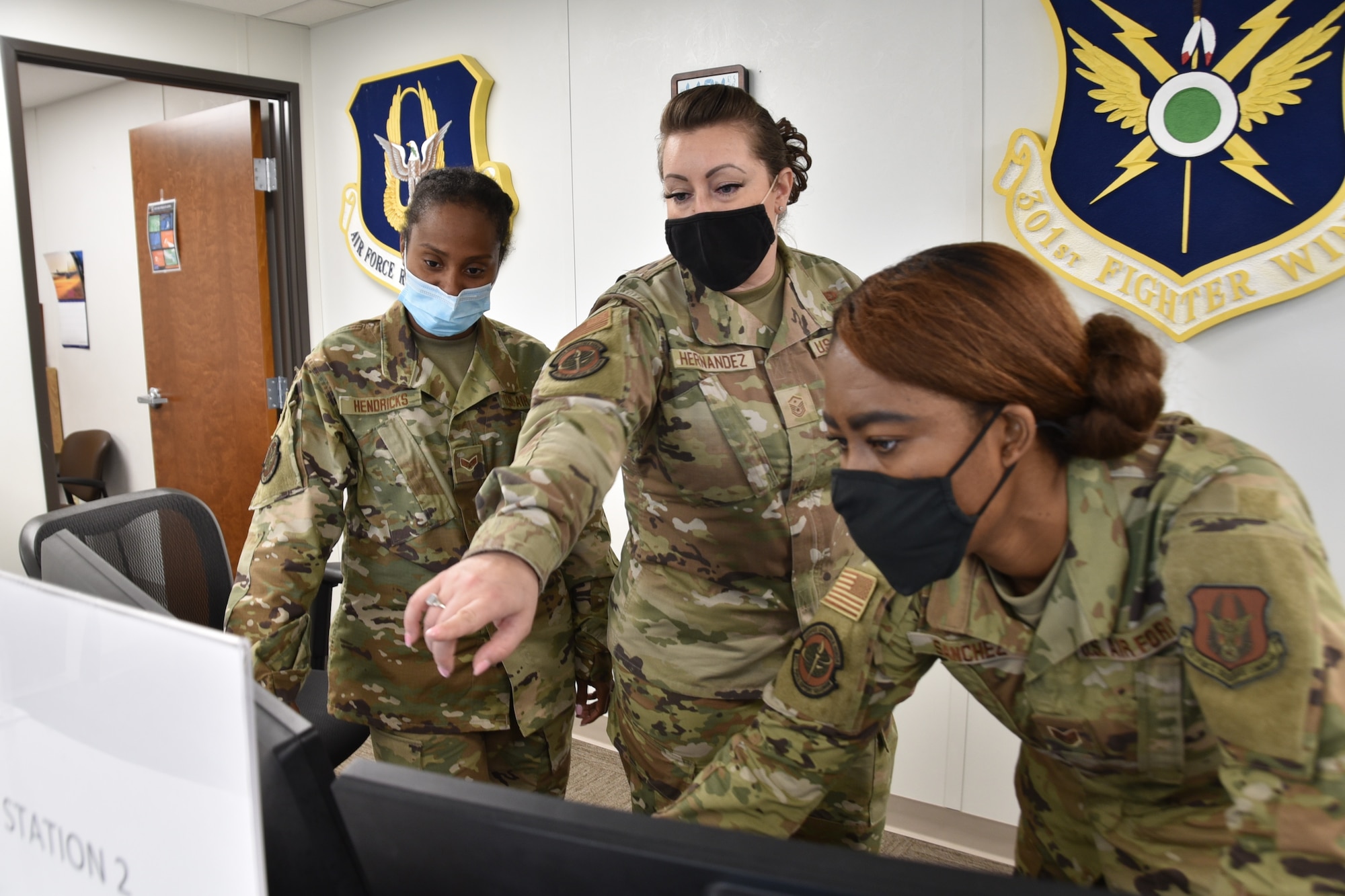 (center) 301st Fighter Wing Force Support Squadron and Wing Staff Agency first sergeant, Master Sgt. Cassandra Hernandez interacts with FSS personalists, Senior Airman Hendricks and Staff Sgt. Sanchez as they show her a new system at U.S. Naval Air Station Joint Reserve Base Fort Worth, Texas on June 5th, 2021. The first sergeant's primary role is to support the mission through interaction, support and management of all unit-assigned personnel and their families. (U.S. Air Force photo by Senior Airman William Downs)