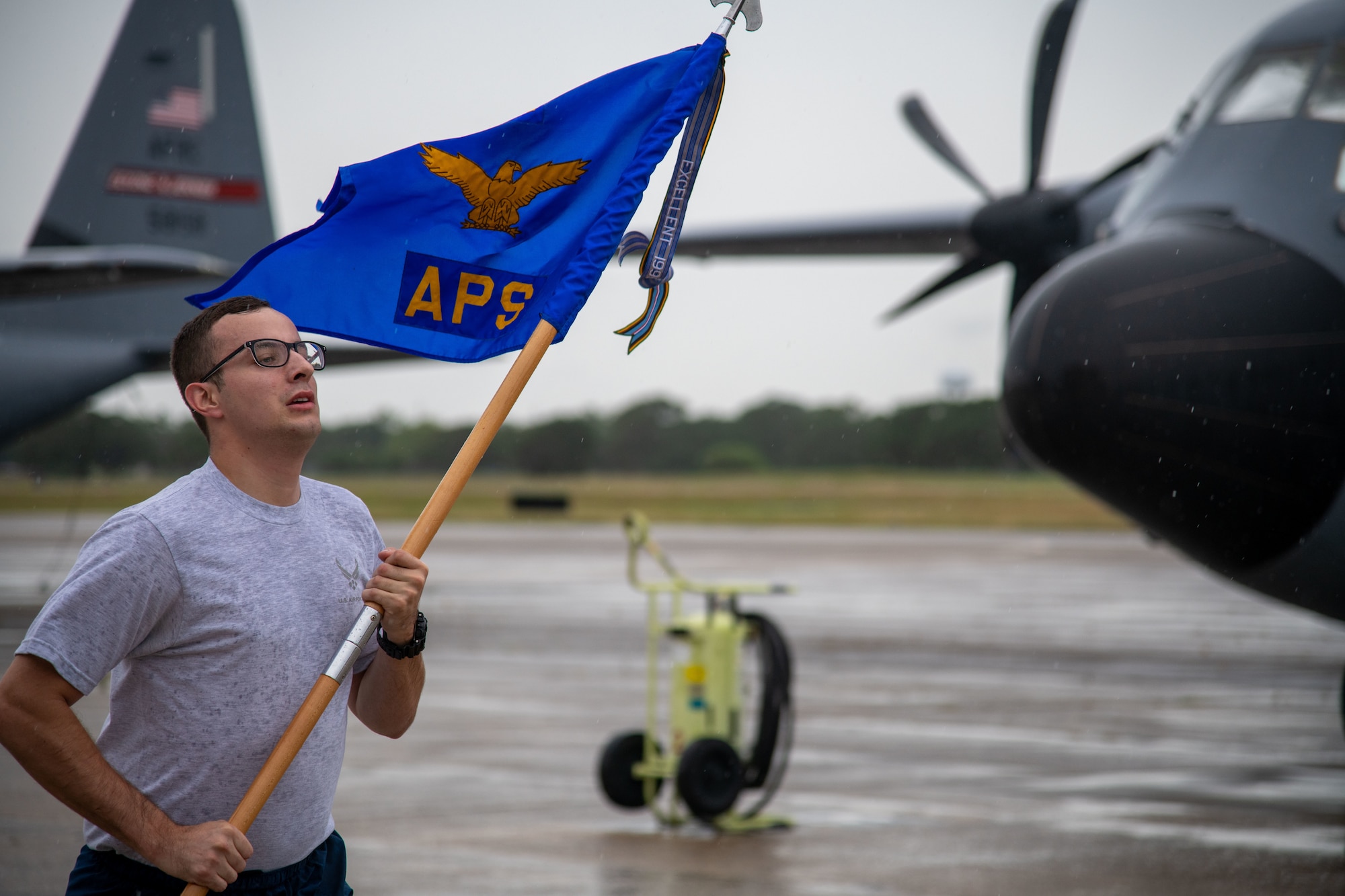 A member of the 41st Aerial Port Squadron at Keesler Air Force Base, Miss., carries the squadron guidon while participating in the “Port Dawg Memorial Run” on the flight line June 5, 2021. Around 50 Reserve Citizen Airmen, from the 403rd Wing commander to junior enlisted Airmen, participated in the event, recognizing and honoring the 12 lives lost in the air transportation career-field. (U.S. Air Force Photo by Staff Sgt. Kristen Pittman)