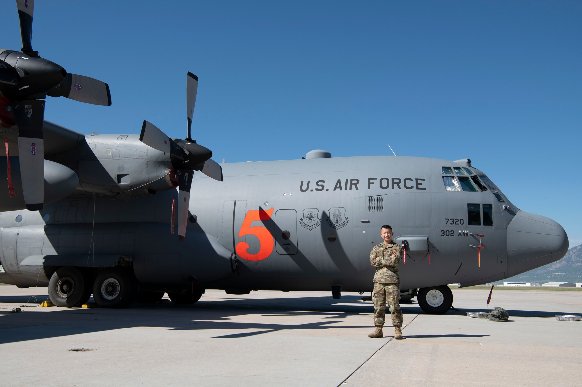 Airman stands in front of C-130