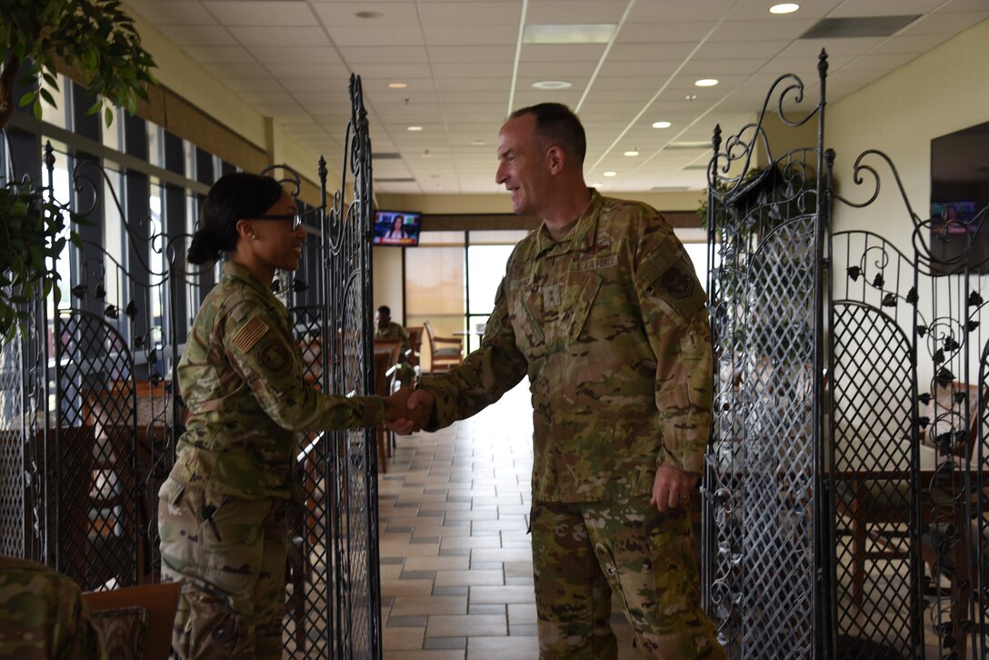 Maj. Gen. John Healy, 22nd Air Force commander, coined Staff Sgt. Courtney Alfred, 36th Aeromedical Evacuation Squadron medical readiness training, during lunch while Healy and Chief Master Sgt. Imelda Johnson, 22nd AF command chief master sergeant, while they were visiting the 403rd Wing June 4-5, 2021.  The visit coincided with the 403rd Wing's change of command, in which Healy presided over the ceremony where Col. Stuart M. Rubio took command from Col. Jeffrey A. Van Dootingh, June 5. (U.S. Air Force photo by Jessica L. Kendziorek)