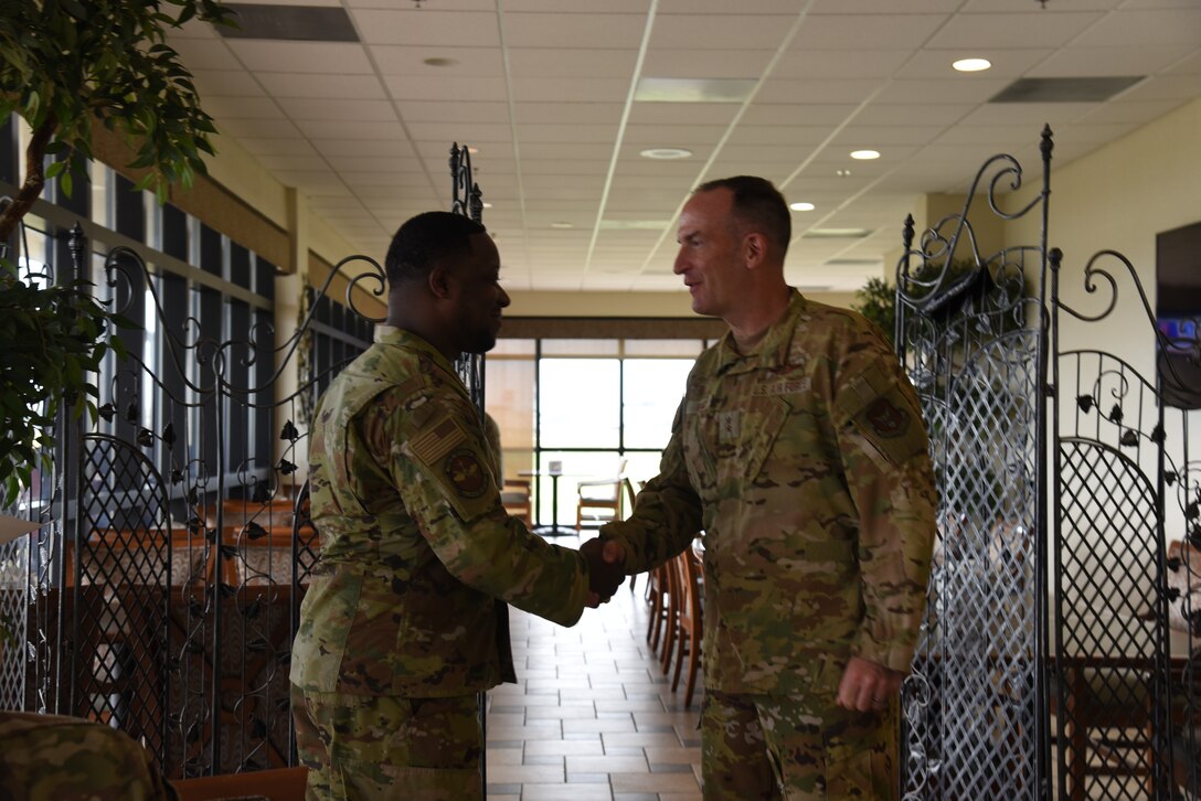 Maj. Gen. John Healy, 22nd Air Force commander, coined Staff Sgt. Jeremy Perryman, 403rd Operations Support Squadron personnel specialist, during lunch while Healy and Chief Master Sgt. Imelda Johnson, 22nd AF command chief master sergeant, while they were visiting the 403rd Wing June 4-5, 2021. The visit coincided with the 403rd Wing's change of command, in which Healy presided over the ceremony where Col. Stuart M. Rubio took command from Col. Jeffrey A. Van Dootingh, June 5. (U.S. Air Force photo by Jessica L. Kendziorek)