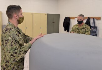 PENSACOLA, Fla. (August 20, 2020)  An AN/SLQ-32(V)6 electronic warfare system training instructor (left), attached to Information Warfare Training Command (IWTC) Corry Station, discusses the course with Rear Adm. Pete Garvin, commander, Naval Education and Training Command (NETC). Garvin, along with NETC Force Master Chief Matthew Harris, visited for a familiarization brief and tour of the Center for Information Warfare Training (CIWT) and IWTC Corry Station onboard Naval Air Station Pensacola Corry Station, Pensacola, Florida. The visit offered an opportunity to update them on CIWT / IWTC Corry Station training and development approaches for building a talented fleet through initiatives, such as Ready, Relevant Learning, that take recruits from "street to fleet" and transform civilians into highly skilled, operational, and combat-ready information warfare warfighters.