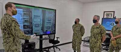 PENSACOLA, Fla. (August 20, 2020) An instructor (left), attached to Information Warfare Training Command (IWTC) Corry Station, gives a Multipurpose Reconfigurable Training System 3D® (MRTS 3D®) technology training demonstration to Rear Adm. Pete Garvin (second from right), commander, Naval Education and Training Command (NETC) along with NETC Force Master Chief Matthew Harris (far right). Garvin, along with Harris, visited for a familiarization brief and tour of the Center for Information Warfare Training (CIWT) and IWTC Corry Station onboard Naval Air Station Pensacola Corry Station, Pensacola, Florida. The visit offered an opportunity to update them on CIWT / IWTC Corry Station training and development approaches for building a talented fleet through initiatives, such as Ready, Relevant Learning, that take recruits from "street to fleet" and transform civilians into highly skilled, operational, and combat-ready information warfare warfighters.