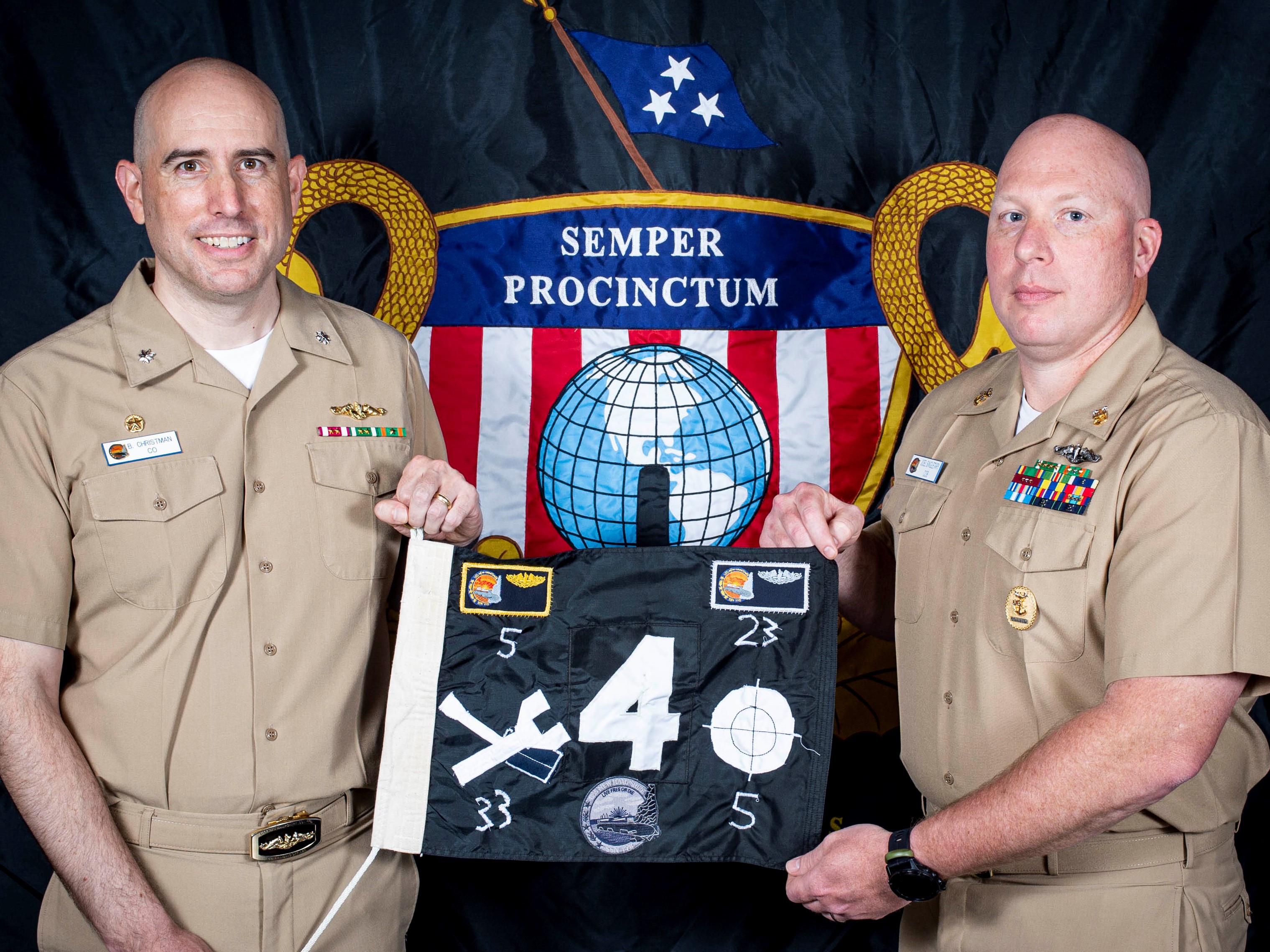 USS New Hampshire's commanding officer and chief of the boat display the boat's battle flag.