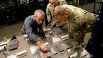 Eric Vannoy, lead welding instructor at Salina Area Technical College, left, inspects the work of Soldiers enrolled in the Advanced Leaders Course for the 91E Allied Trade Specialist military occupational specialty qualification course at the Kansas Army National Guard’s Regional Training Site for Maintenance in Salina, Kansas, May 20, 2021. The KSARNG-SATC  partnership gives Soldiers completing the Army course the opportunity to enroll in and receive credit for college courses.