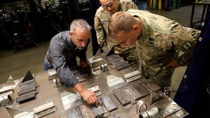 Eric Vannoy, lead welding instructor at Salina Area Technical College, left, inspects the work of Soldiers enrolled in the Advanced Leaders Course for the 91E Allied Trade Specialist military occupational specialty qualification course at the Kansas Army National Guard’s Regional Training Site for Maintenance in Salina, Kansas, May 20, 2021. The KSARNG-SATC  partnership gives Soldiers completing the Army course the opportunity to enroll in and receive credit for college courses.