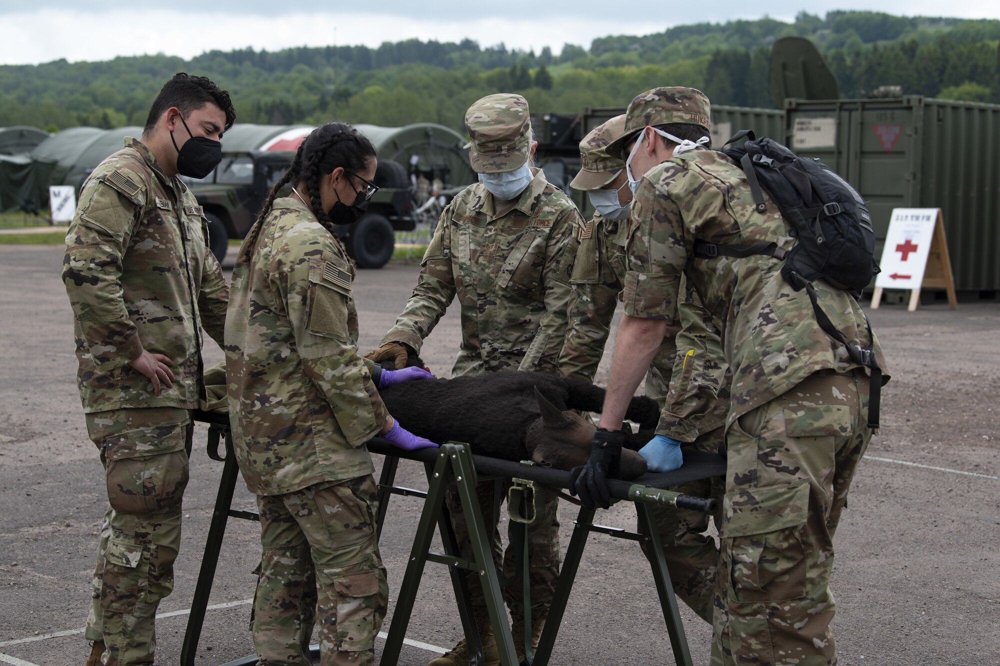 U.S. Army Sgt. Victoria Fuentes, Animal Care Specialist (center) provides military working dog care training to 52nd Medical Group Airmen during exercise Saber Guardian 21 at Baumholder, Germany, June 3, 2021. “Diesel”, an advanced canine medical trainer is a wireless veterinary training manikin that simulates common traumatic injuries experienced by military working dogs. (U.S. Air Force photo by Tech. Sgt. Tony Plyler)